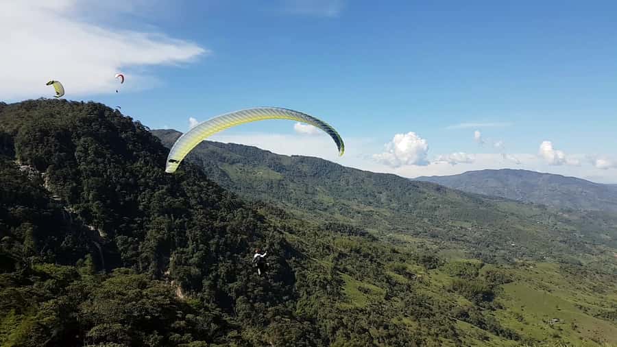 From Medellin: Private Paragliding Tour Over Waterfalls - Preparing for a flight above the canyons